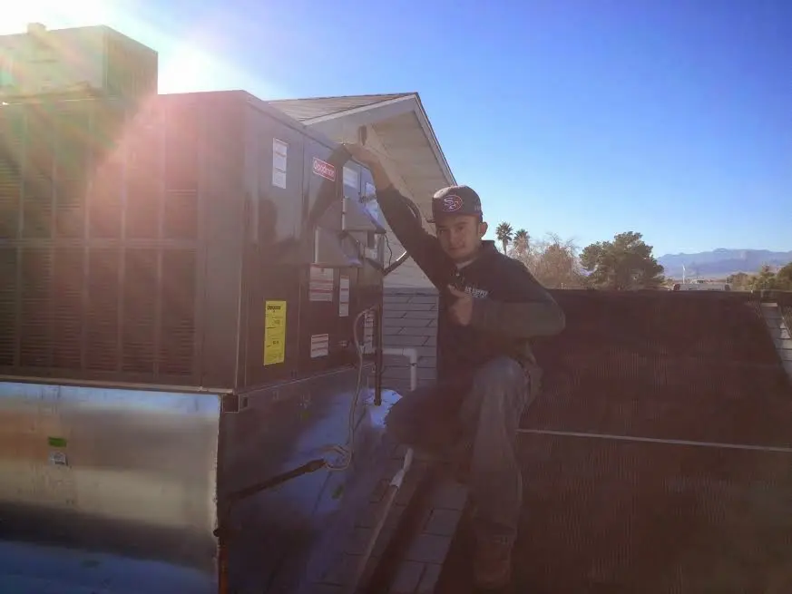 HVAC technician performing Air Duct Repair on a rooftop unit in Redding
